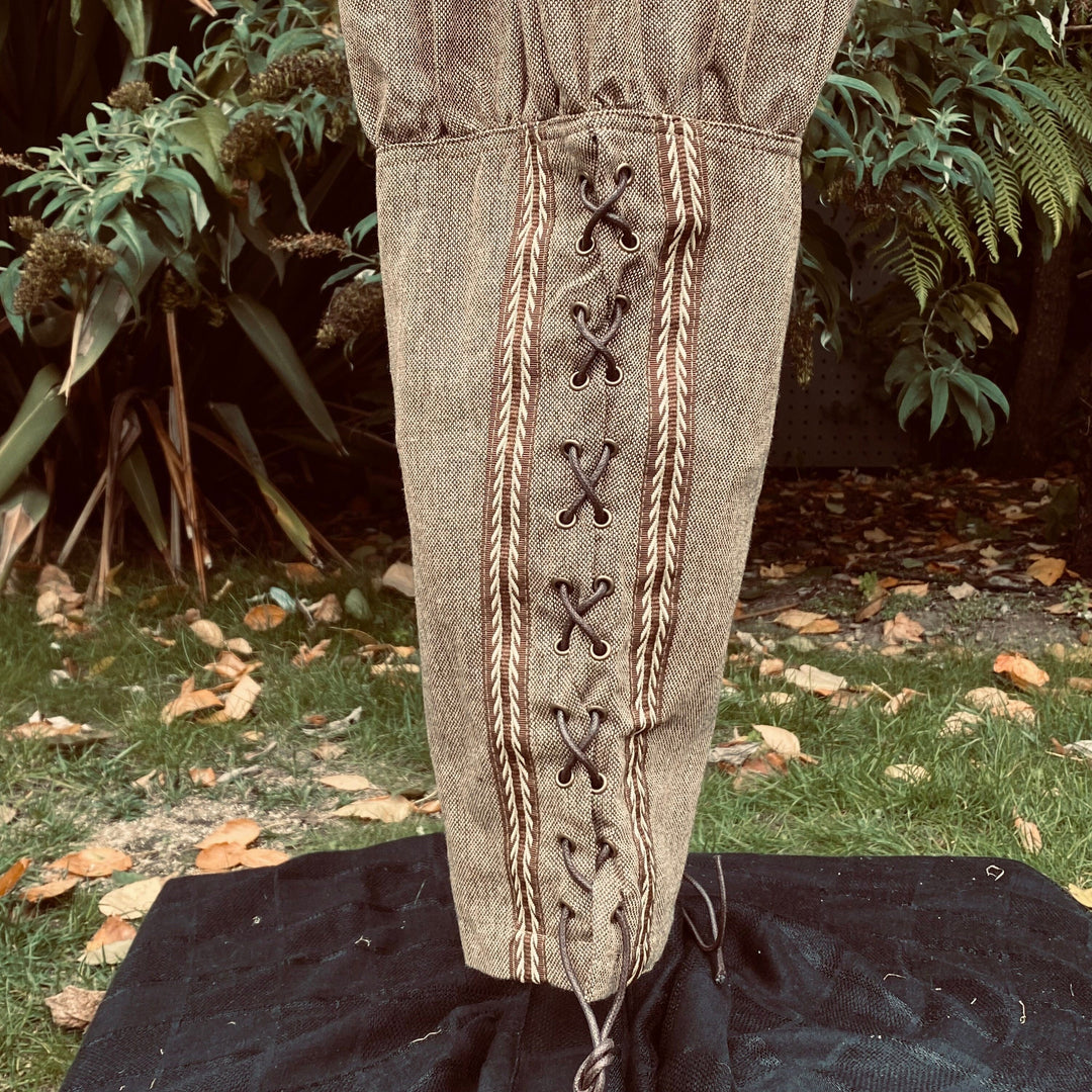 close up of braiding and lacing detail on brown wool pants.