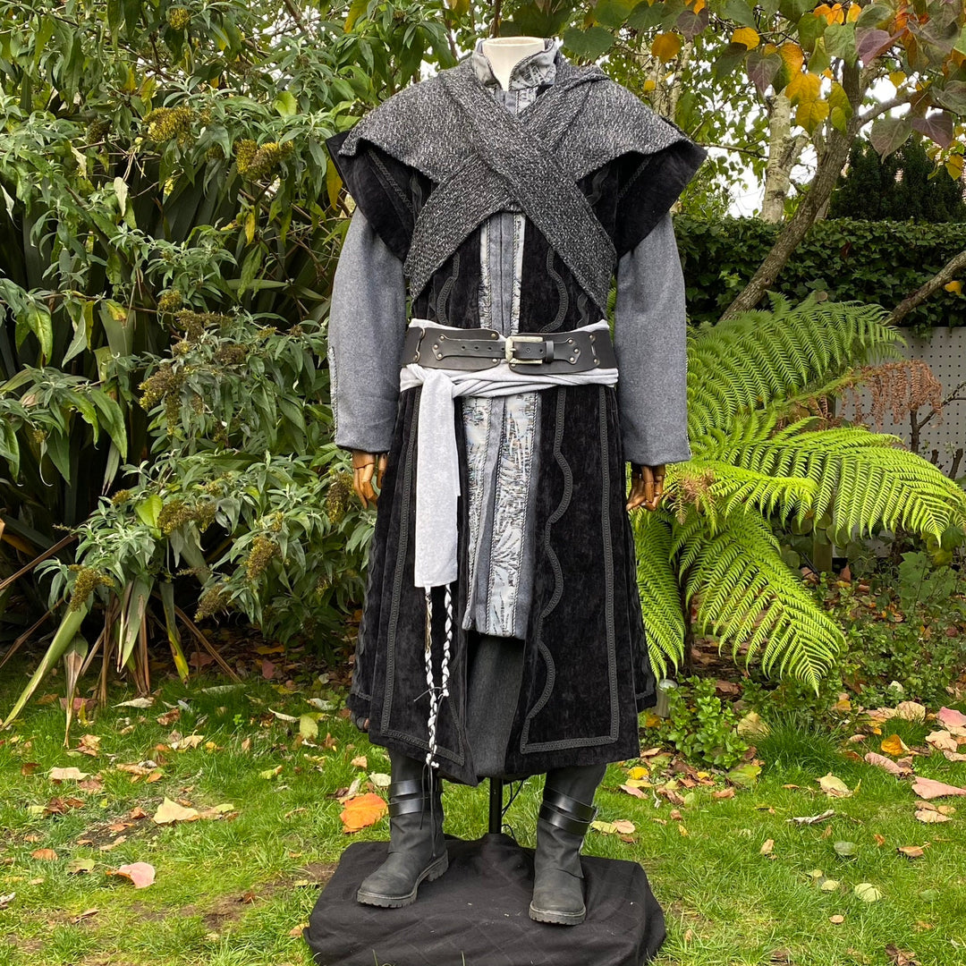 Medieval LARP outfit with layered coat and sash in garden scene.