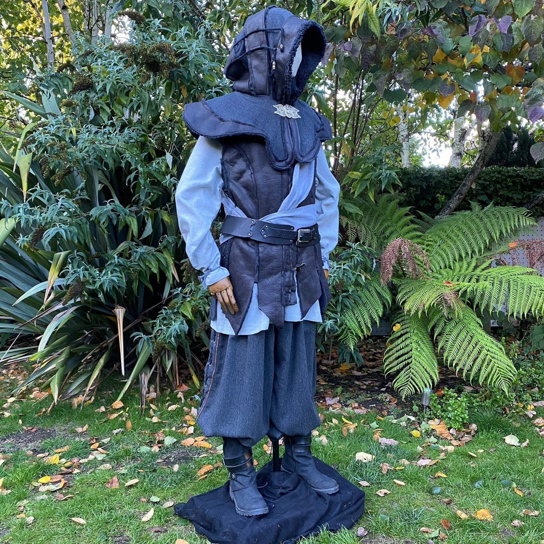 Medieval LARP outfit side view, featuring a black hood and waistcoat, grey cotton shirt, and sash.