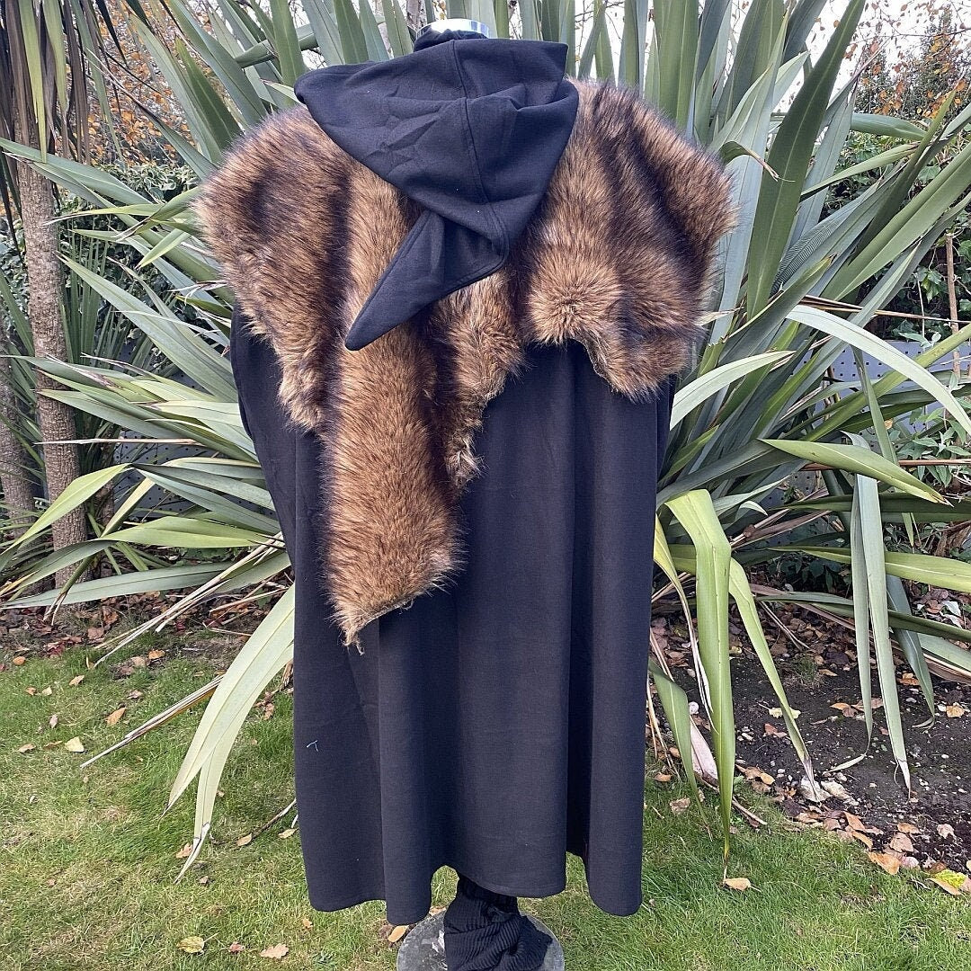 Black cloak with pointed hood, faux fur mantle, back view in garden setting, LARP attire.