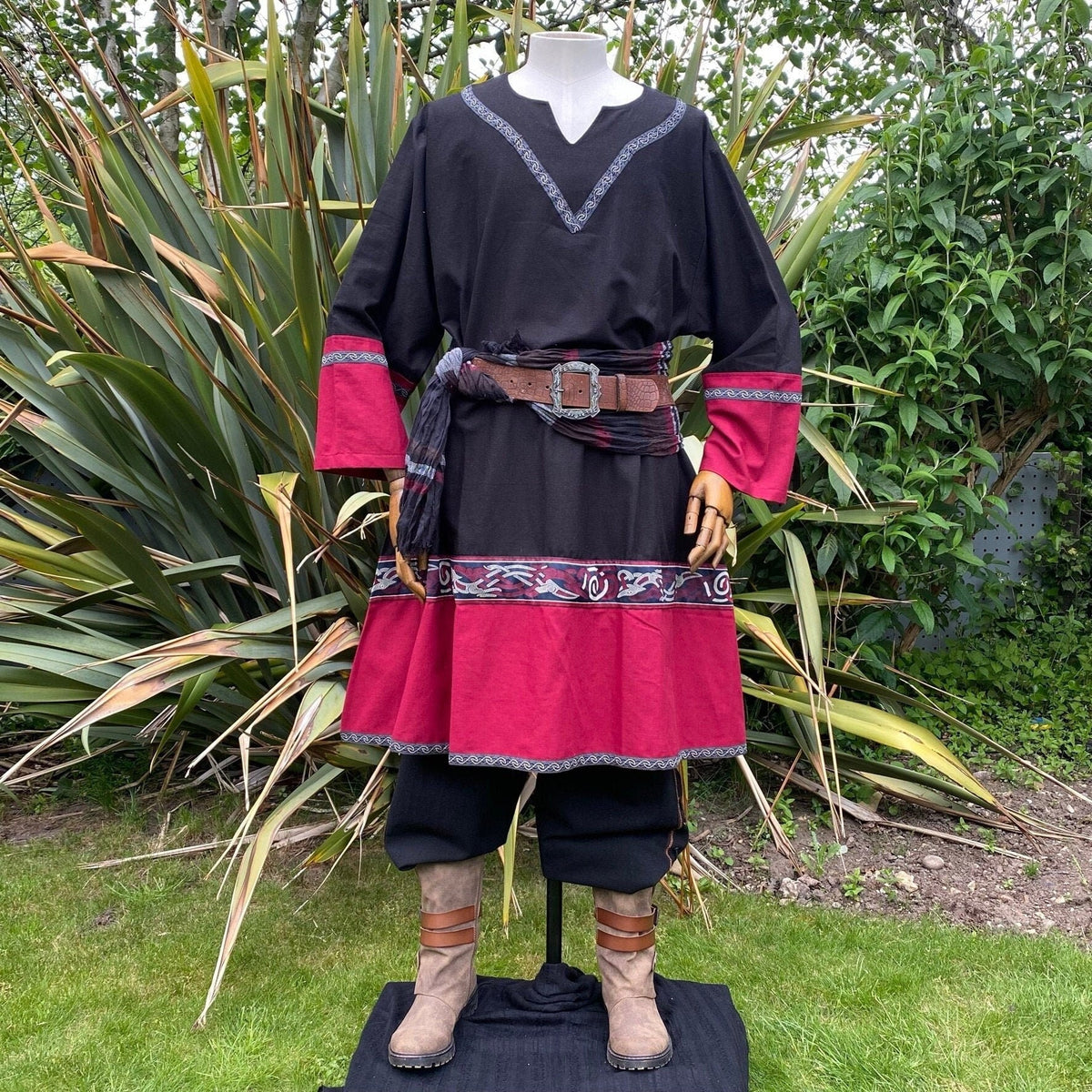 Black-red Viking tunic with belt, nature backdrop, LARP medieval attire.