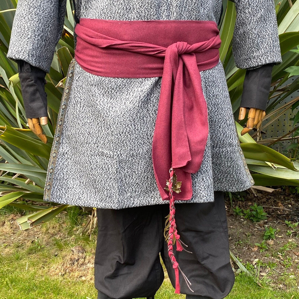 Red wool sash tied over a medieval tunic, fringe detail for LARP events.