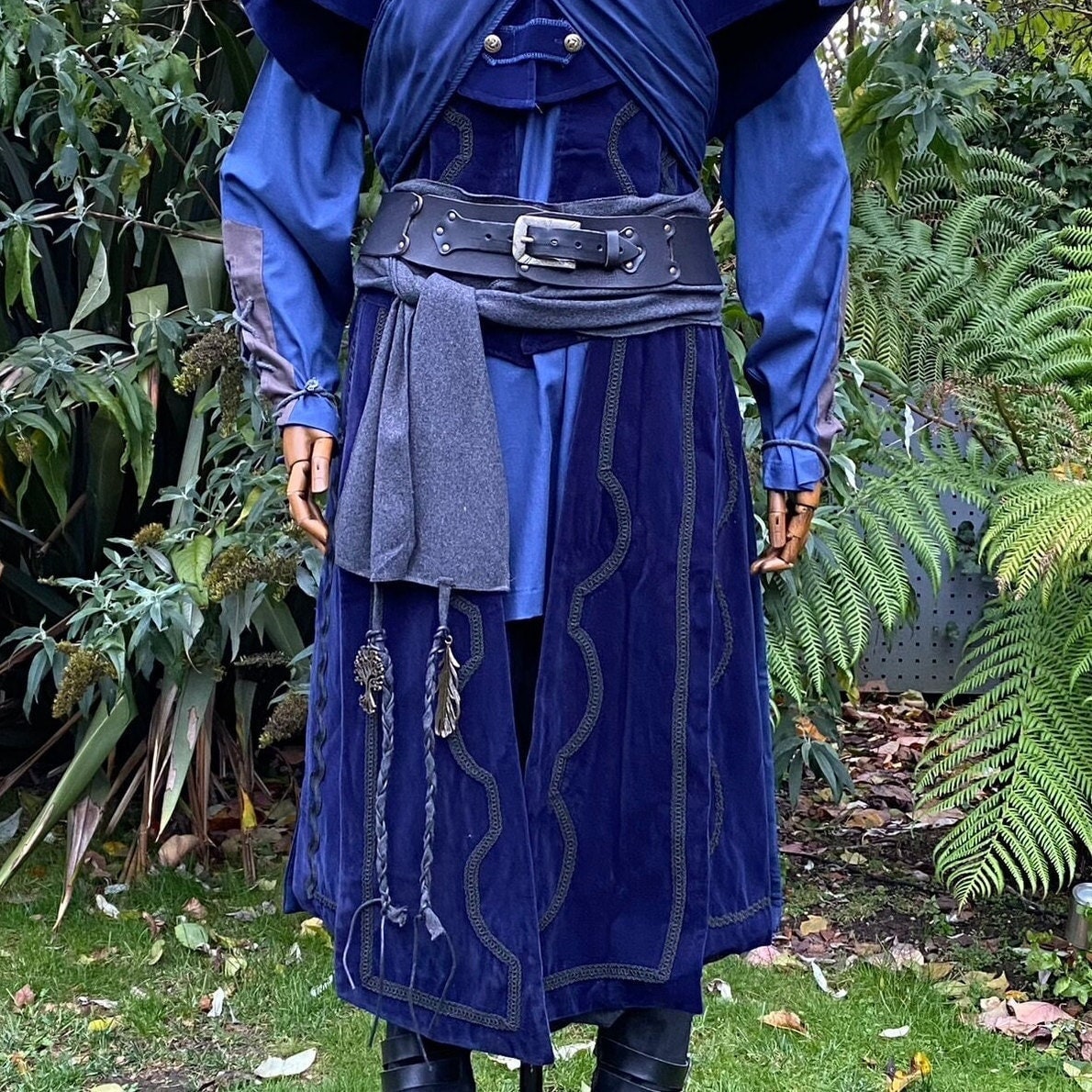 Dark grey sash tied on blue medieval tunic with black LARP leather belt.