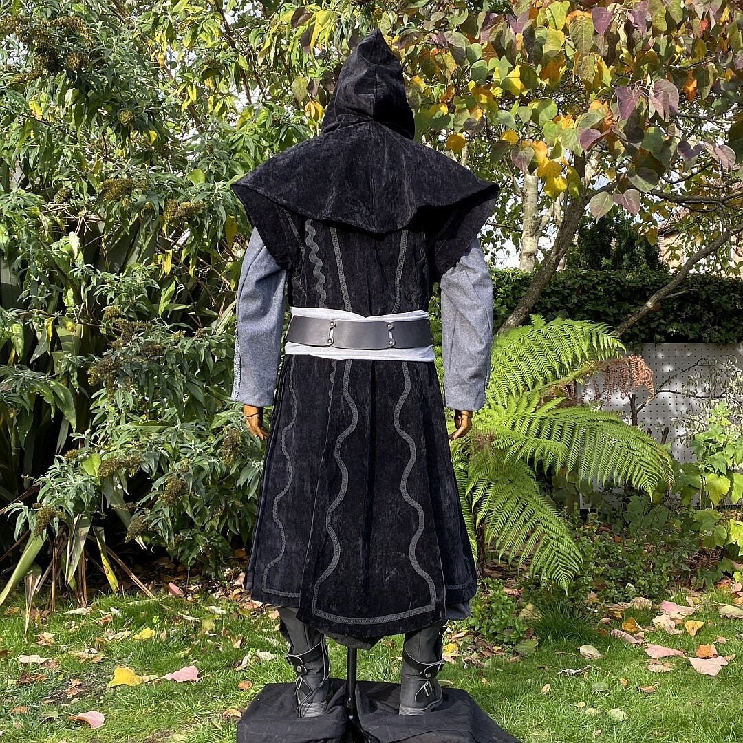 Back view of medieval LARP outfit with hooded coat and wide sash.
