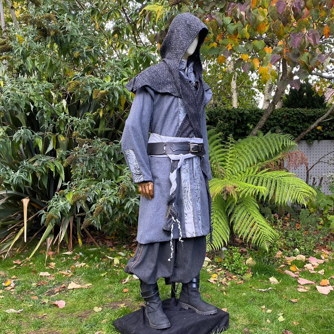 Elven LARP attire in a garden; detailed grey coat with hood and sash.