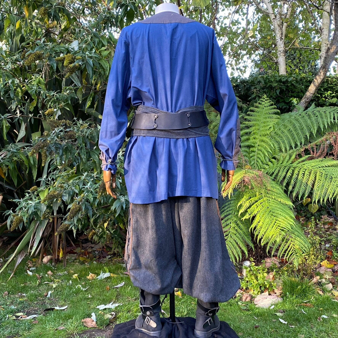Back view of LARP outfit in blue-grey, forest background, with sash detail.