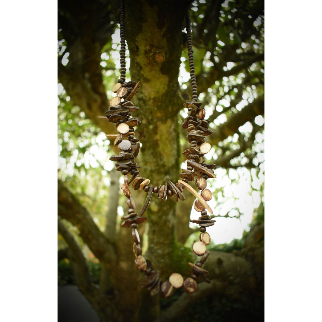 Double-strand tooth necklace on tree branch for medieval LARP cosplay.