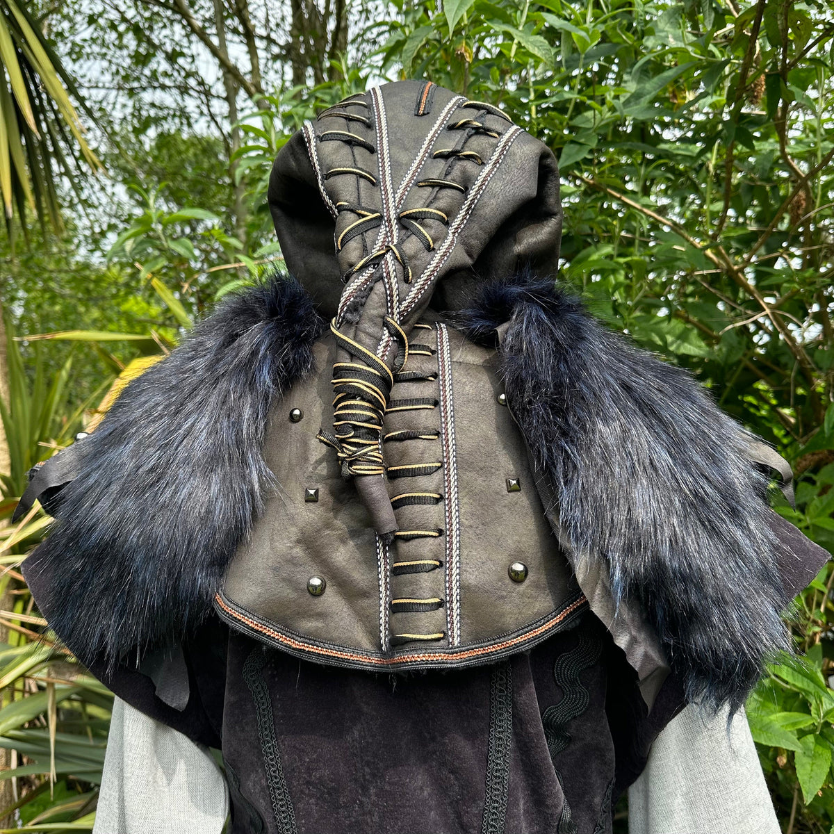 Back view of black LARP hood with elaborate lacing and blue faux fur.
