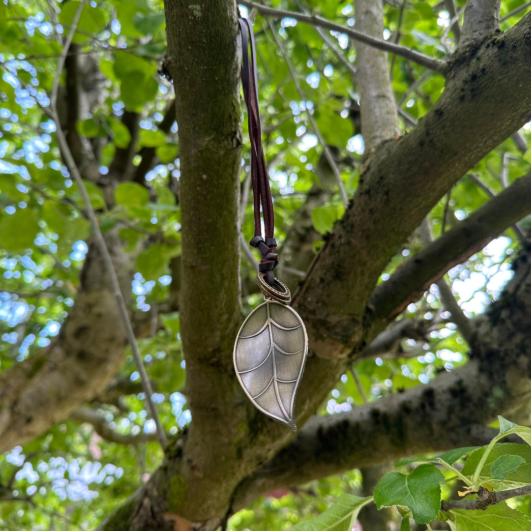 Silver leaf necklace on leather cord hanging in forest for LARP.