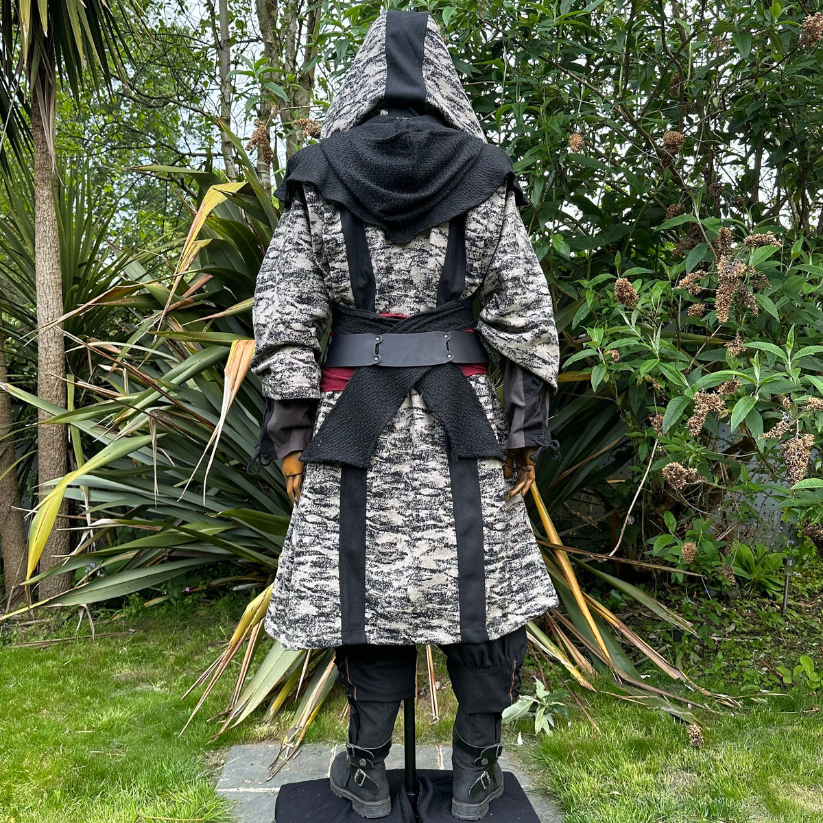 Medieval LARP costume back view, featuring brown and black hooded robe, wool hood, shirt.