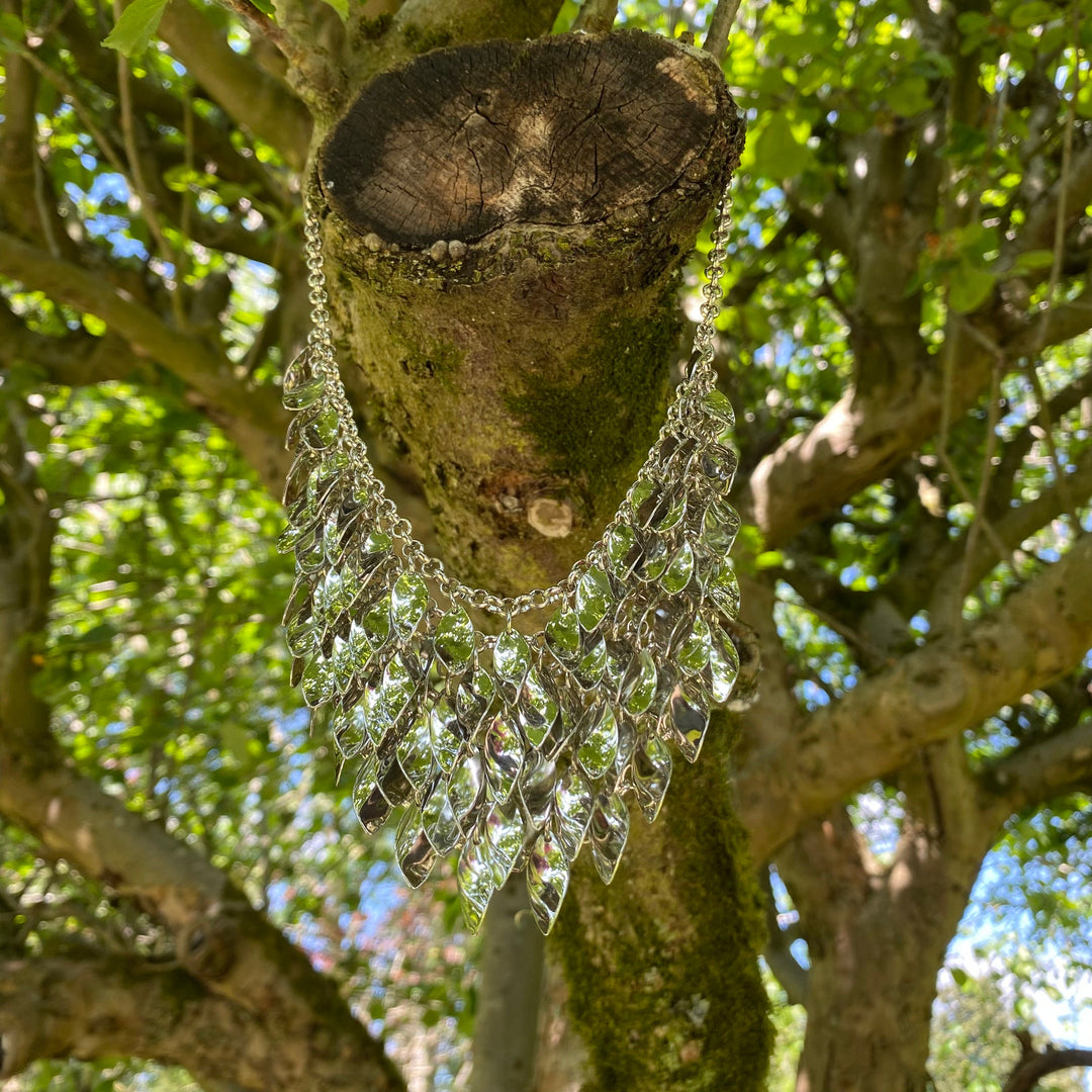 Silver chainmail leaf necklace hangs on tree for LARP.