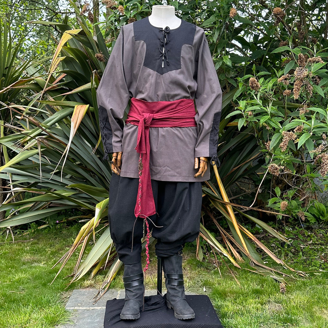 Medieval LARP attire with red sash, grey shirt.