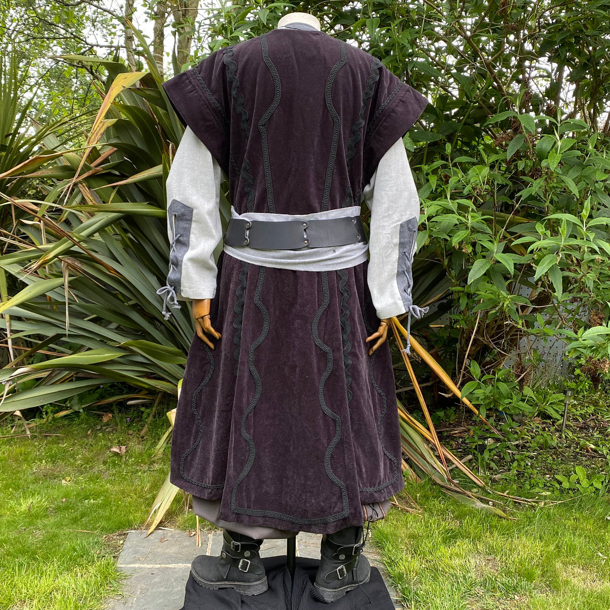 Back view of medieval waistcoat with ornate braid, grey suede effect.