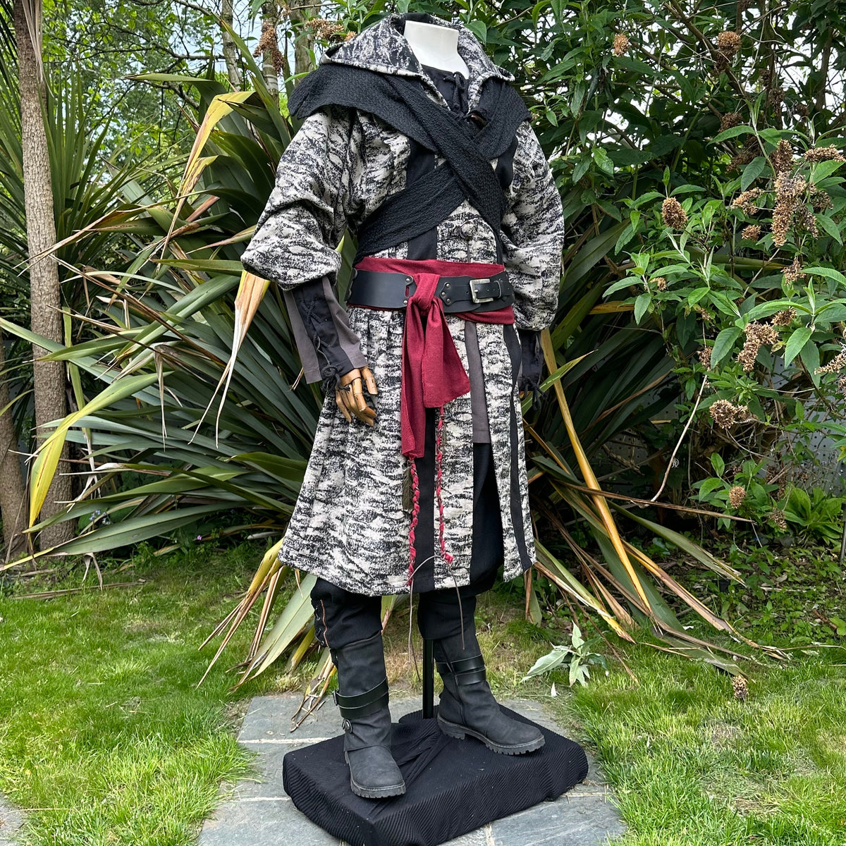 Medieval LARP costume side view, featuring brown and black hooded robe, wool hood, shirt.