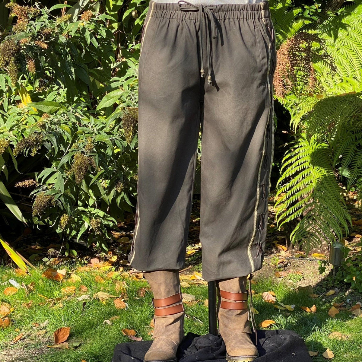 Side view of green-grey LARP pants with lace detailing.