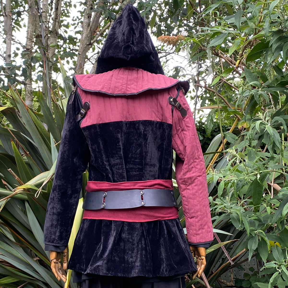 Back angle of LARP rogue outfit with black hood, red trim, and leather belt.