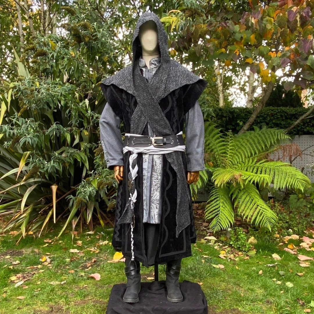 Hooded LARP costume in garden backdrop, showcasing detailed black coat.